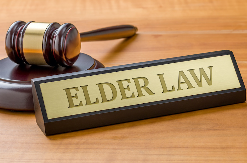 A gavel and a name plate with the engraving Elder law