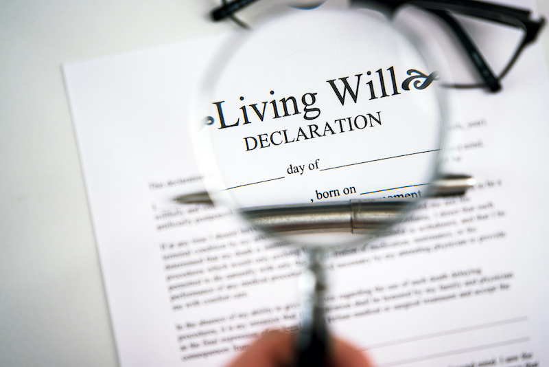 Living will declaration form seen through magnifying glass.