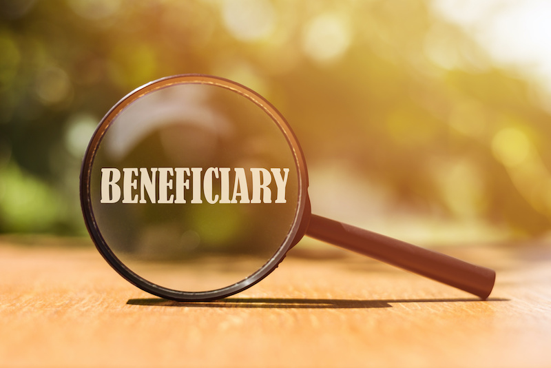 The word BENEFICIARY on magnifier in sunlight.