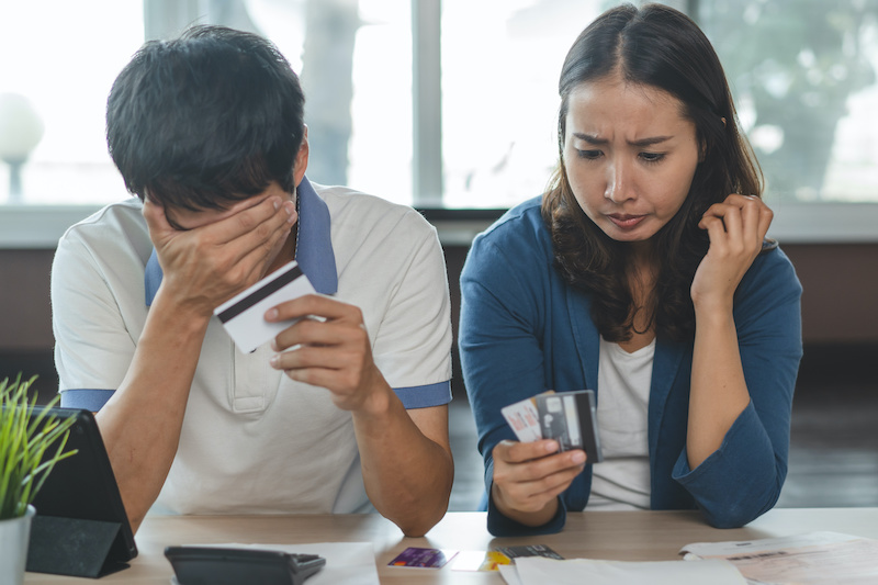 Family financial crisis concept. Stressed couple calculating credit card debt.