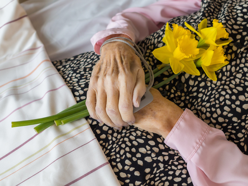 A dead woman with her hands folded on the stomach, holding daffodils