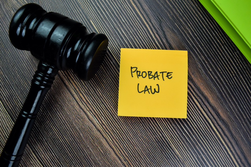 Concept of Probate Law write on sticky notes with gavel isolated on Wooden Table.