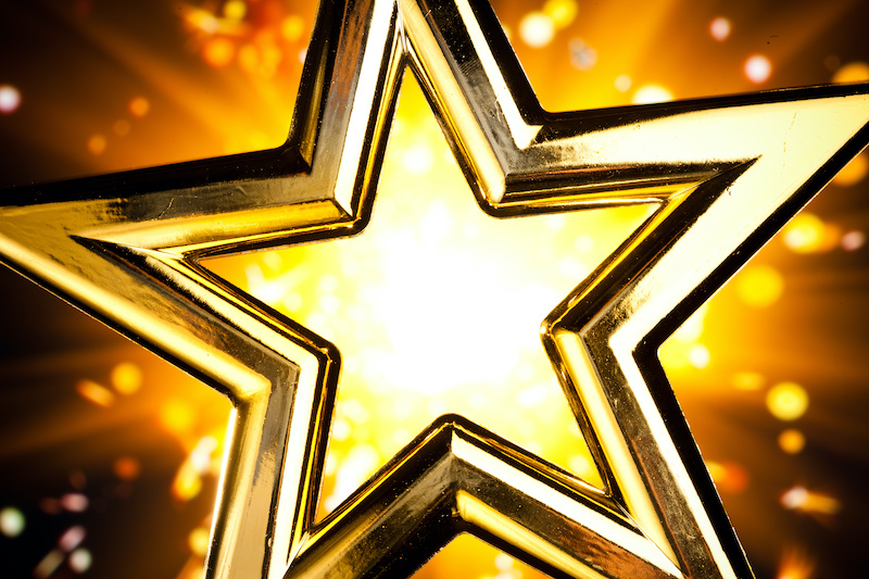 shiny gold star against orange fireworks background
