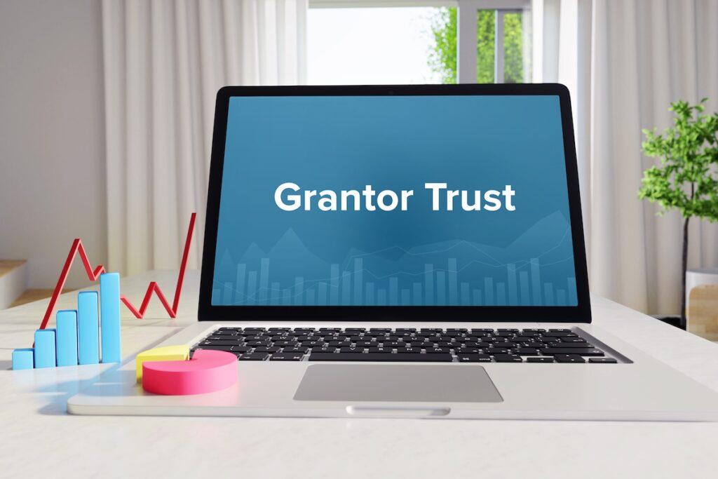 Grantor Trust – Statistics/Business. Laptop in the office with term on the Screen. Finance/Economy.