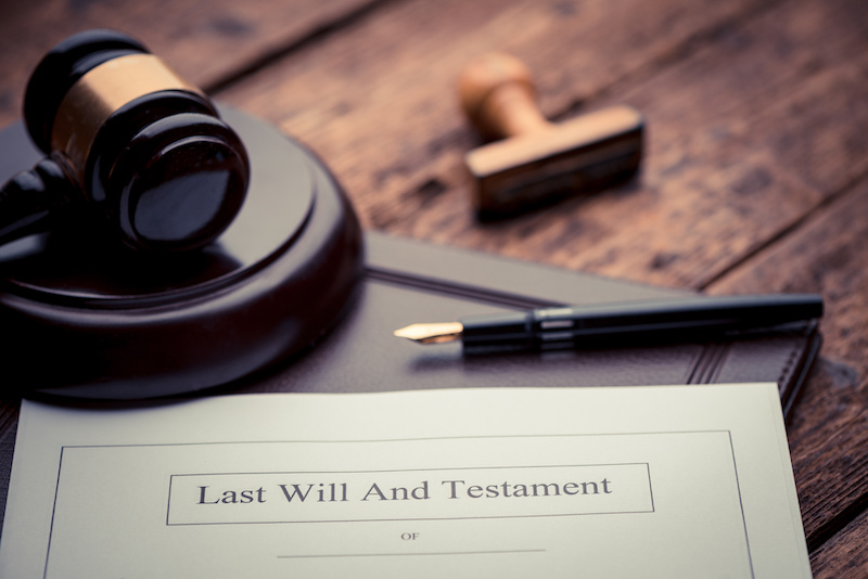 Last Will and testament document on wooden table close up