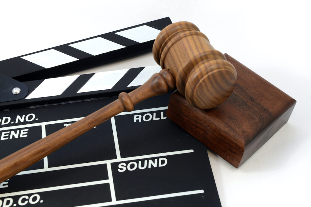 A clapboard and gavel for concepts related to movie production laws and regulations.
