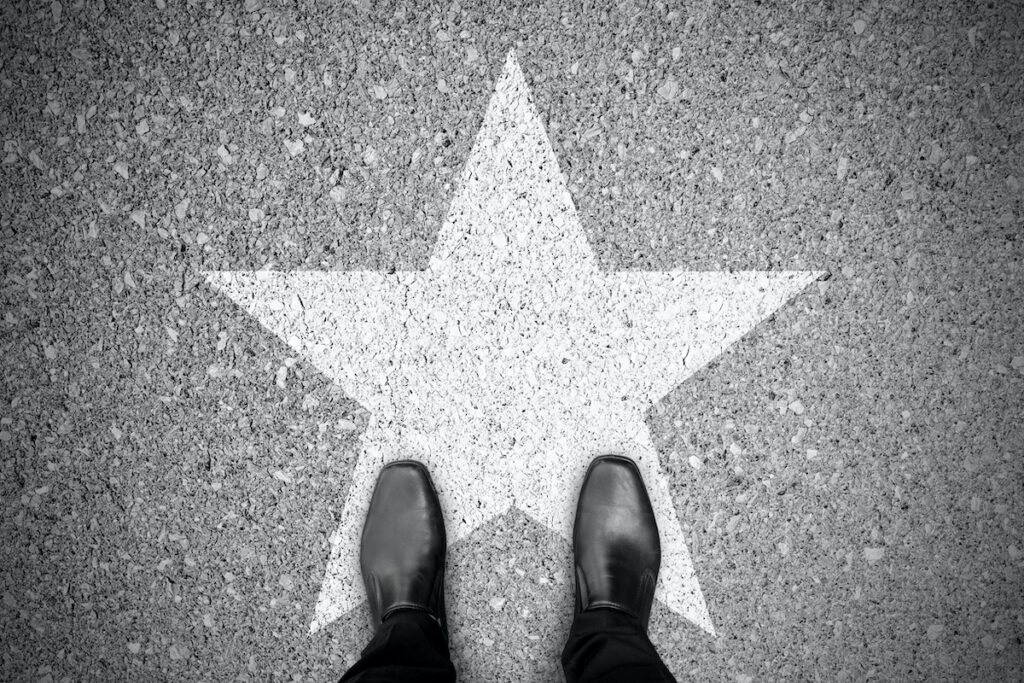 Business concept. Businessman standing on the street and star sign on the floor.