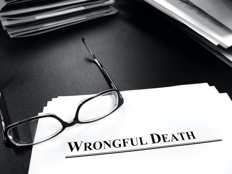 Wrongful death papers on desk with glasses for legal services or lawsuit