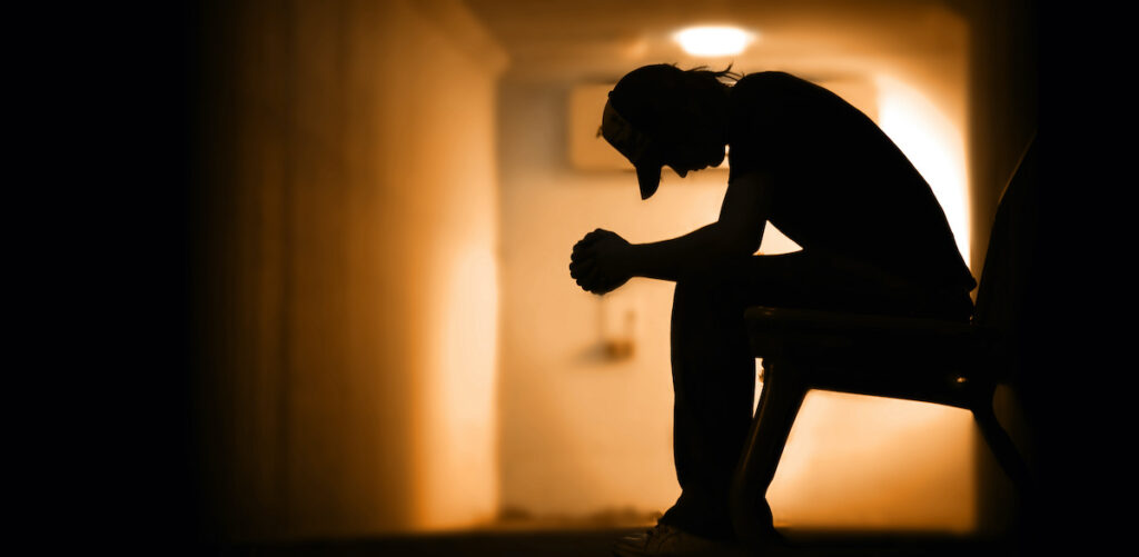 Young man with hands clasped together addiction