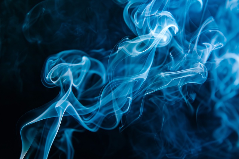 A close up of blue smoke on a black background.