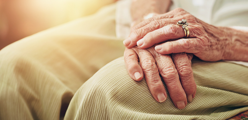 Closeup, morning and hands of senior woman in retirement home for thinking, reflection and nostalgia in house. Old age, living room and elderly person with ring for relaxing, calm and widow on sofa.