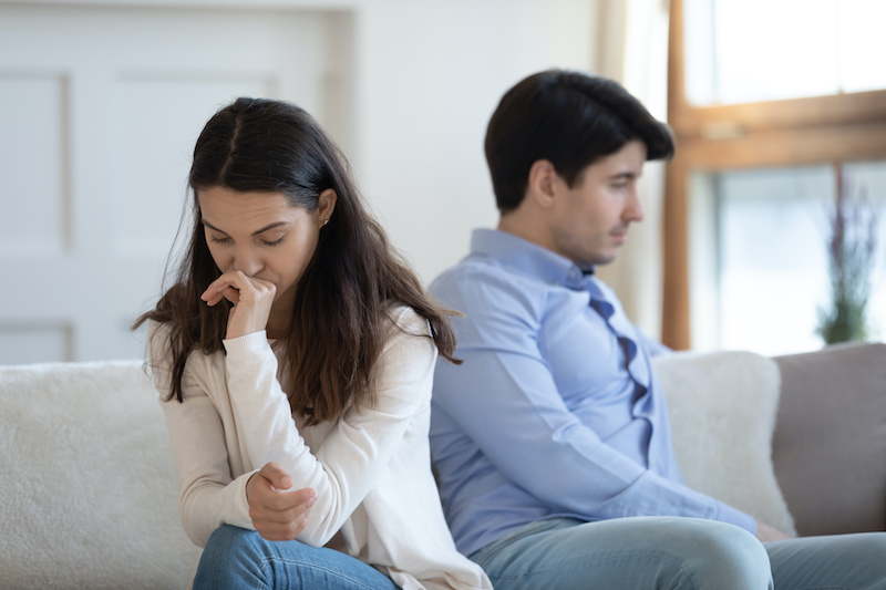 After quarrel. Indifferent insulted sad upset man and woman friends, lovers or spouses sitting on sofa turning away from one another avoid communicating and speaking, thinking about breakup or divorce