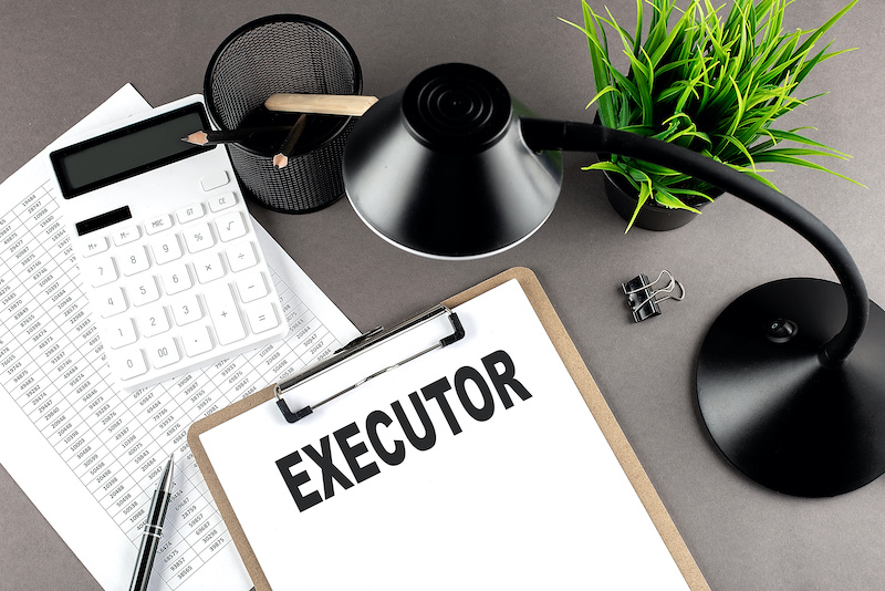 Clipboard ,chart and calculator, lamp and workspace accessories on grey table. Top view , text EXECUTOR