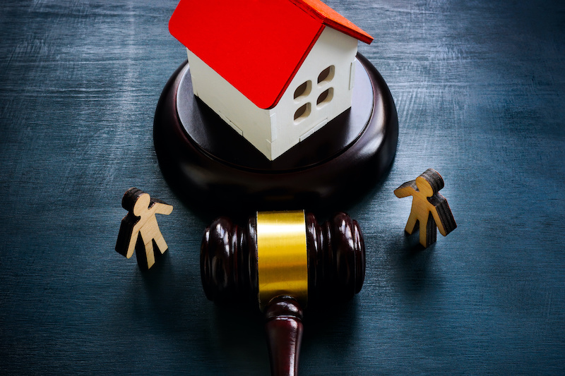 Figurines, model of a house and a gavel, as a concept of inheritance law.