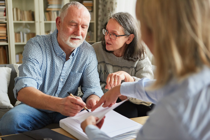 Seniors sign a contract or power of attorney at home after a consultation