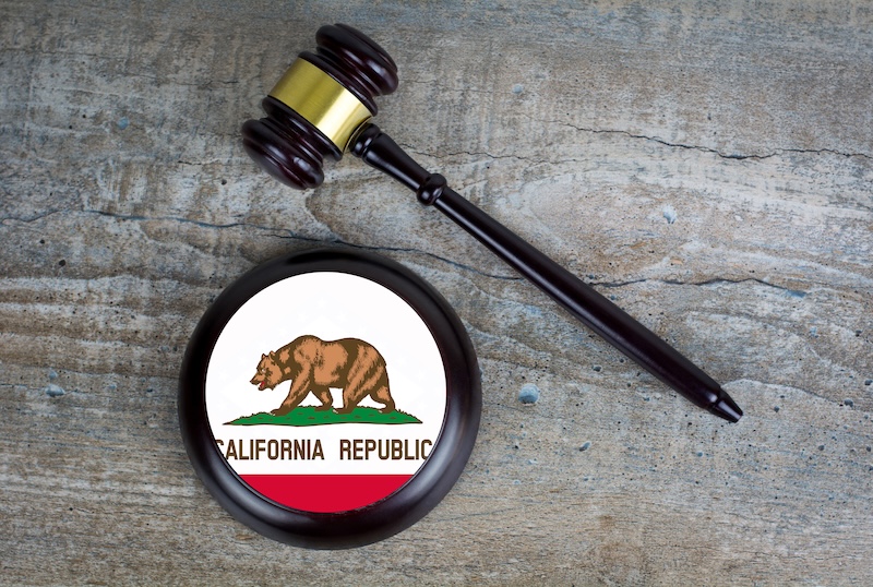 Wooden judgement or auction mallet with of California flag. Conceptual image.