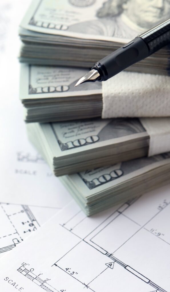 Big amount of US dollars money bills with pen and planning blueprints of residential building project close up. Investment and construction project concept