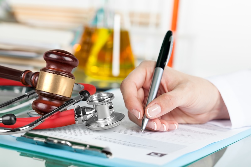 Doctor writing and medical stethoscope on the desk military estate planning