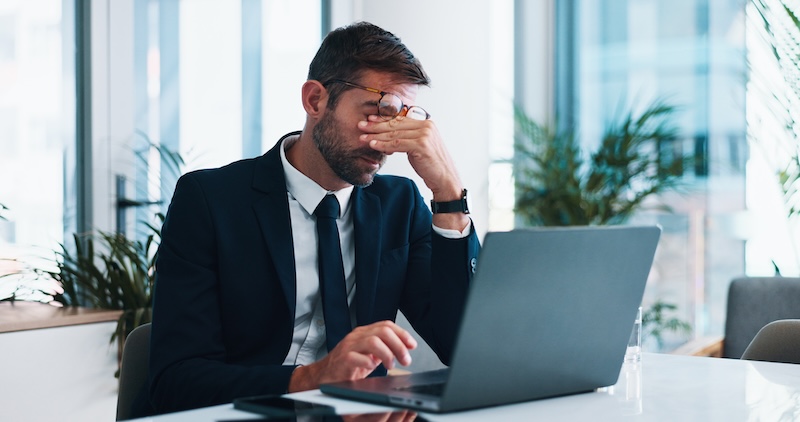 Frustrated, businessman or headache with laptop for stress, mistake or corporate bankruptcy at office. Man, employee or accountant with fail or migraine on computer for debt, financial crisis or loss.