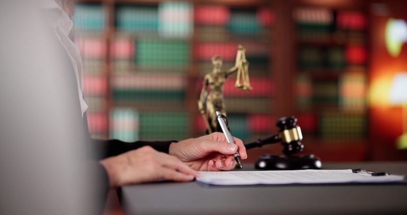 Professional Lawyer Signing Legal Document In Courthouse, Key Business Image.