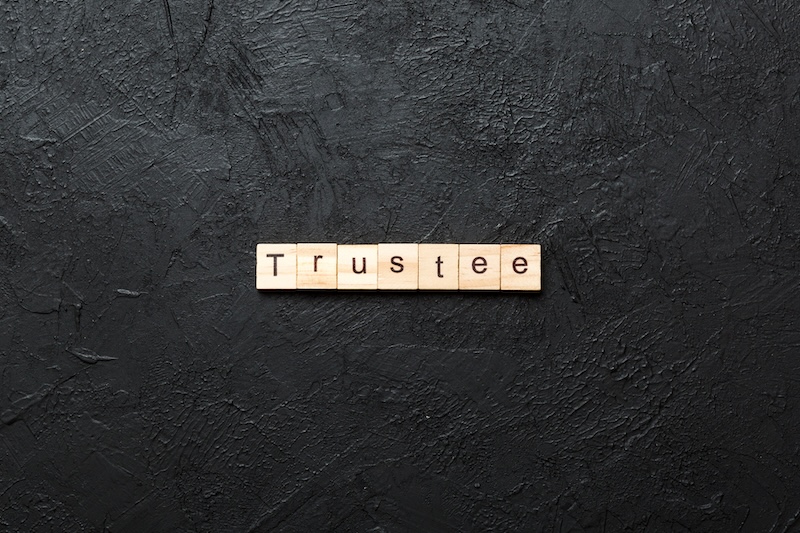 trustee word written on wood block. trustee text on table, concept.