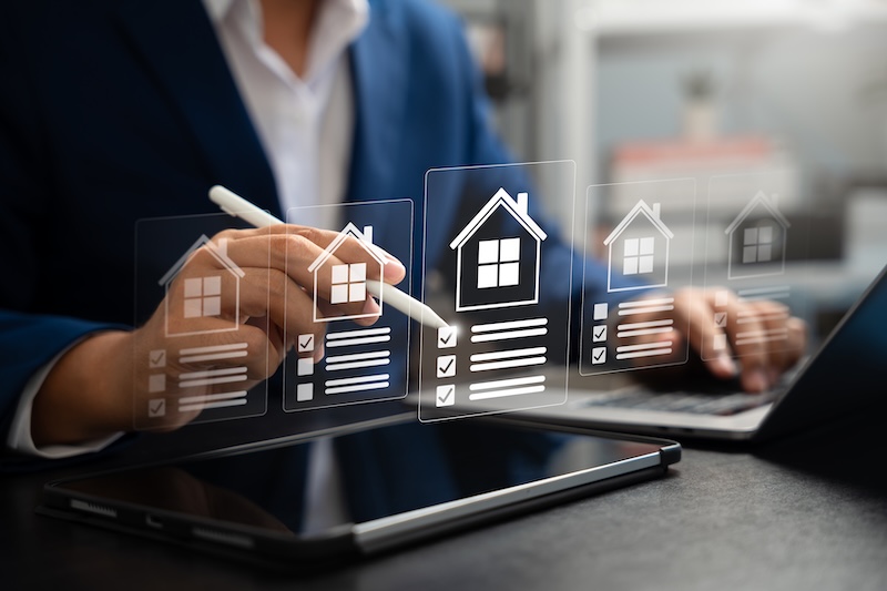 Businessman reviews real estate documents on laptop, Online property management, Digital housing contract, investment planning, Smart organization of real estate transactions using modern tools.