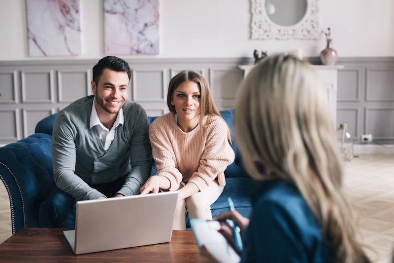 Real-estate agent shows a build project to a young couple. Man and woman on consultation.