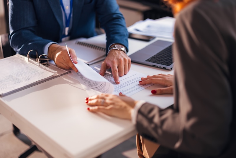 The real estate agent closes the deal with the client and they sign the contract.
