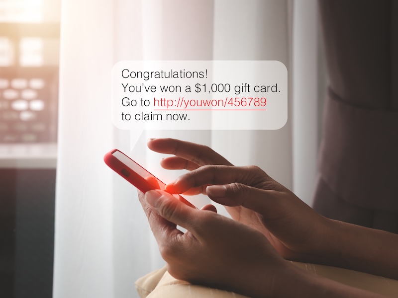 SMS scam, scams link from scammer for malware installing concept. Text messages, Winning congratulations phishing text with link tracking in speech bubble showing while woman use mobile phone at home.