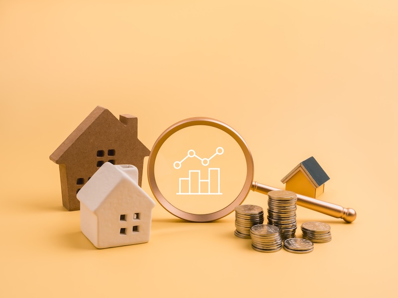 Real estate investment and property analysis concept with various houses, magnifying glass, chart icon, and coins stacks. Financial due diligence, asset growth, and housing market trends concept.