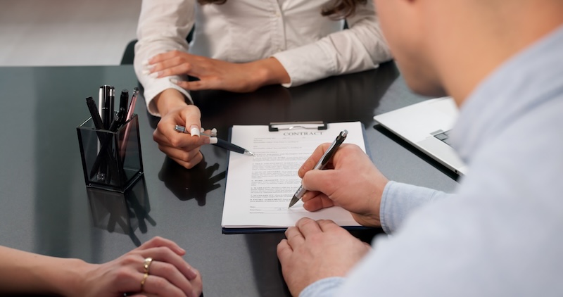 Young Couple Signing Mortgage Contract For New House Loan Approval.
