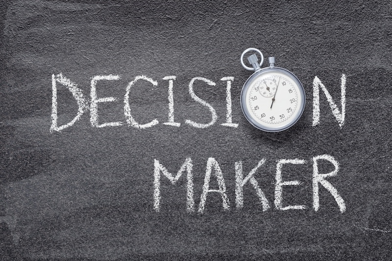 decision maker phrase written on chalkboard with vintage precise stopwatch