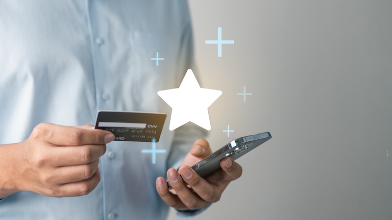 redeem, points, loyalty, rewards, voucher, coupon, cash back, membership, Hand holding credit card and smartphone with reward icon represents redeem points, loyalty programs, and cashback promotions.