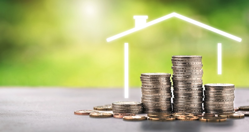 House outline over stacked coins mortgage investment concept for home financing property savings real estate loan security and residential wealth growth